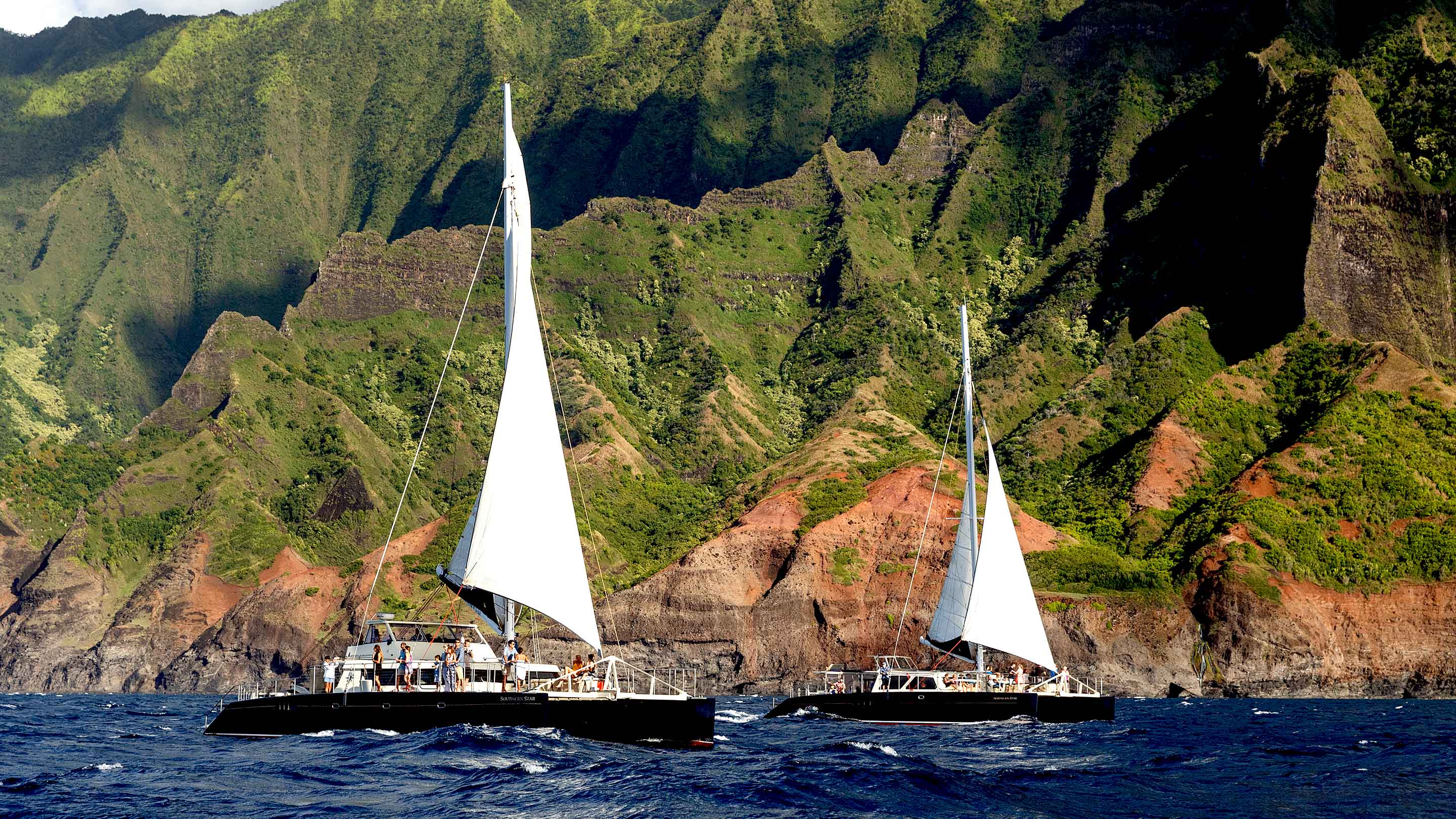 Capt Andy's NaPali Star catamarans sailing along Napali Kauai.