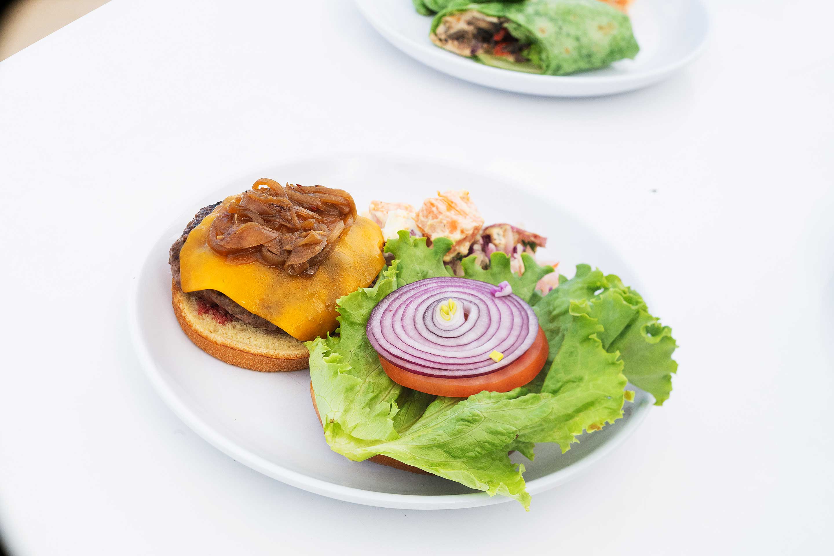 BBQ cheeseburger with grilled onions and potato salad